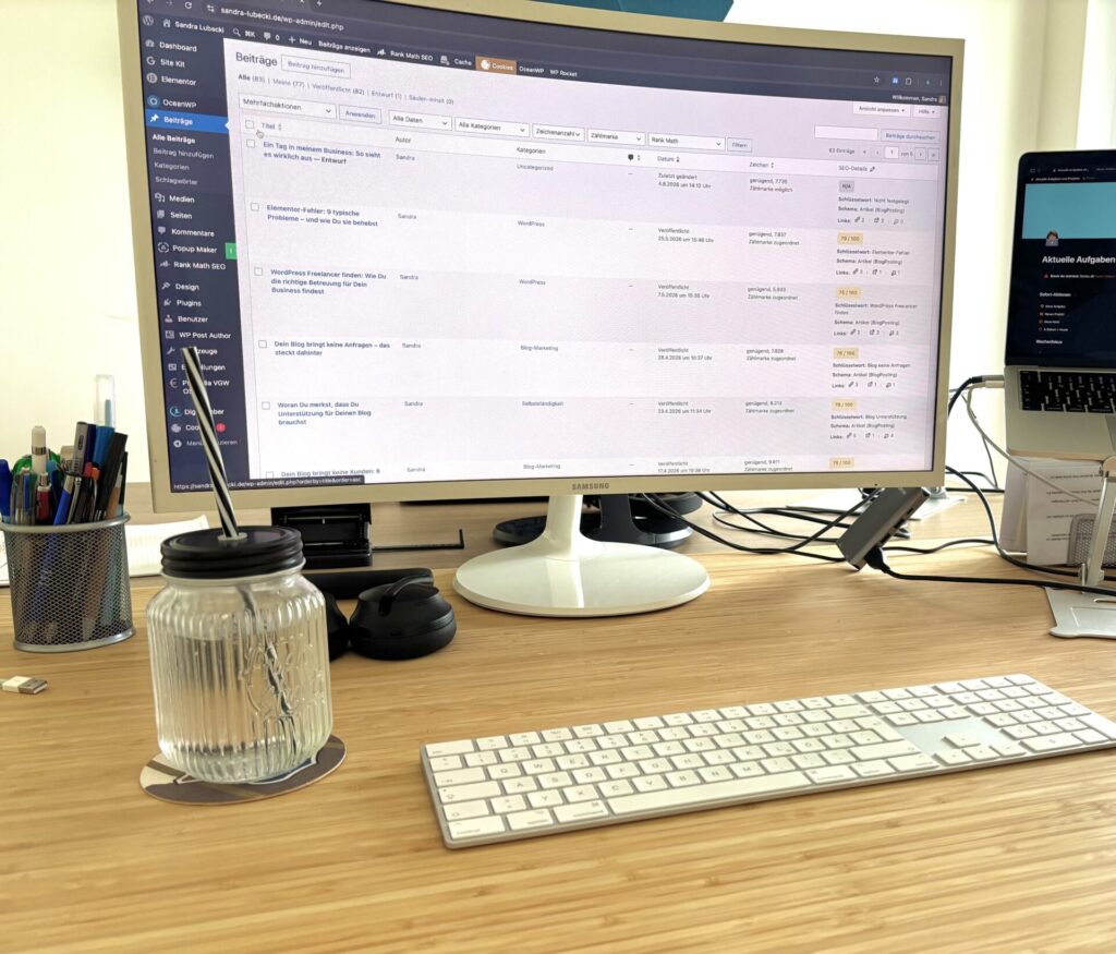Gesamtansicht des aufgeräumten Arbeitsplatzes mit einem höhenverstellbaren Schreibtisch, einem großen Curved-Monitor und einem Laptop daneben.